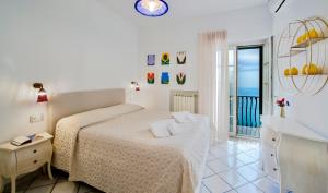 a white bedroom with a bed and a sink at Villa Il Lupo Felice - Panoramic Sea View Villa, Ravello in Ravello