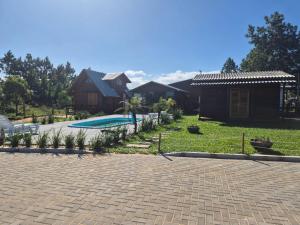 a backyard with a house and a swimming pool at Cabanas das Oliveiras in Torres
