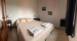 a bedroom with a bed with two towels on it at Buena Vista Trevelin II in Trevelín