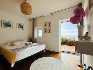 a bedroom with a bed and a large window at Villa Escola da Bica in Arco da Calheta +43 photos