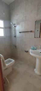 a bathroom with a shower and a toilet and a sink at Private Rooms For Rent Near Airport - Raha Hostel in Ḩayl Āl ‘Umayr