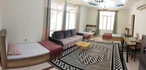 a living room with a bed and a couch at Private Rooms For Rent Near Airport - Raha Hostel in Ḩayl Āl ‘Umayr