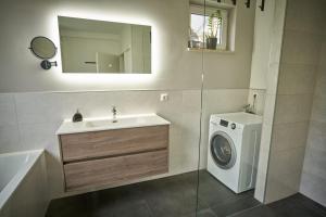a bathroom with a sink and a washing machine at *Premium-Apartment im Spreewald* in Burg