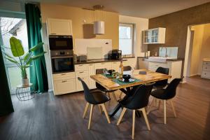 a kitchen with a wooden table and chairs at *Premium-Apartment im Spreewald* in Burg