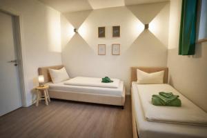 a room with two beds and a table with a stool at *Premium-Apartment im Spreewald* in Burg