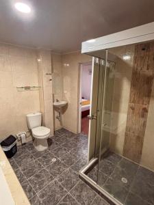 a bathroom with a toilet and a glass shower at Hotel Colonial San Felipe in Girón +51 photos