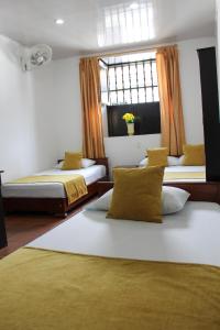 a bedroom with two beds and a window at Hotel Colonial San Felipe in Girón