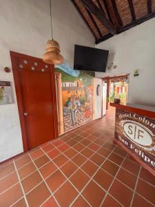 a dining room with a tiled floor and a flat screen tv at Hotel Colonial San Felipe in Girón