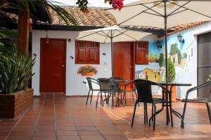 a patio with chairs and tables and umbrellas at Hotel Colonial San Felipe in Girón