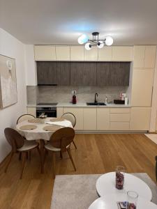 a kitchen with a table and chairs in a room at Maya 2 apartman sa dve spavace sobe in Vrnjačka Banja