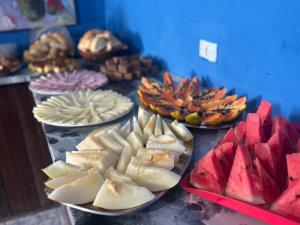 a table topped with plates of watermelon and other foods at POUSADA BELLA SPIAGGIA in Paraty