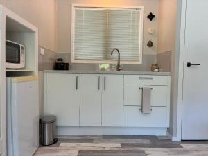 a kitchen with a sink and a microwave at Relax in the Garden Suite in Thames +13 photos