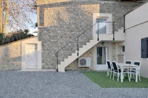 a table and chairs in front of a building at Coeur de pierre in Vallon-Pont-dʼArc