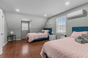 a bedroom with two beds and two windows at Evergreen Villa Poconos - Hot Tub, Fire Pit, Close to Kalahari, Great Wolf Lodge and Camelback in Tobyhanna +23 photos