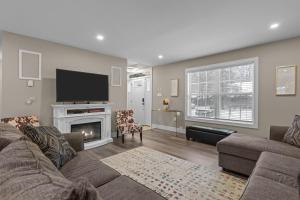 a living room with a couch and a fireplace at Evergreen Villa Poconos - Hot Tub, Fire Pit, Close to Kalahari, Great Wolf Lodge and Camelback in Tobyhanna