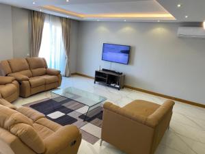 a living room with two couches and a flat screen tv at Ocean Breeze Apartment in Maputo +6 photos