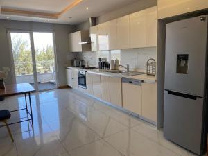 a large kitchen with white cabinets and a large window at Ocean Breeze Apartment in Maputo
