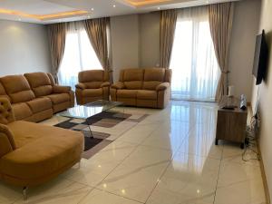 a living room with two couches and a television at Ocean Breeze Apartment in Maputo