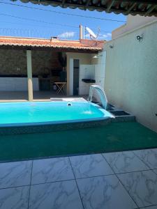 a swimming pool with a fountain in a house at Casa Camocim Marilago in Camocim