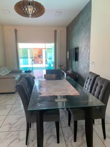 a dining room with a glass table and chairs at Casa Camocim Marilago in Camocim