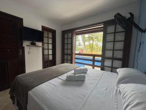 a bedroom with a bed with two towels on it at POUSADA BELLA SPIAGGIA in Paraty