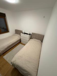 a white room with a bed and a couch at Maya 2 apartman sa dve spavace sobe in Vrnjačka Banja