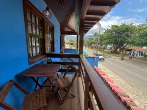 a table and chairs on the balcony of a house at POUSADA BELLA SPIAGGIA in Paraty