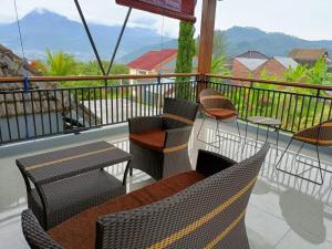 a balcony with chairs and tables and a view at Villa Oentoeng 1 Private Pool 3 Kamar in Punten