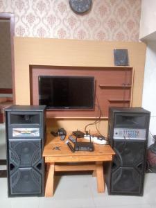 a living room with a table with two speakers and a tv at Villa Oentoeng 1 Private Pool 3 Kamar in Punten