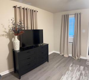 a living room with a television on a dresser at Skipper Apt 1 in Rockingham