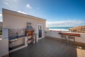 a kitchen with a fireplace and a view of the ocean at Terregal in Ajuy