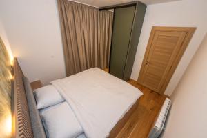 a small bedroom with a bed and a door at The Watermill Lodge in Kolašin