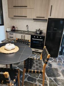 a kitchen with a table and chairs and a sink at Φεγγαρόπετρα ΓΑΙΟΦΩΣ in Kalívia
