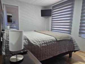 a bedroom with a bed and a table with a lamp at Alojamiento Costanera in Laraquete
