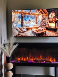 a living room with a fireplace with a tv above it at Φεγγαρόπετρα ΓΑΙΟΦΩΣ in Kalívia