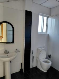 a bathroom with a sink and a toilet and a mirror at Lovely beach hotel in Negombo