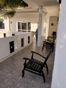 two benches sitting on a porch with a fireplace at Lovely beach hotel in Negombo