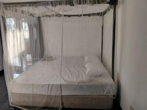 a bed with a canopy in a room at Lovely beach hotel in Negombo
