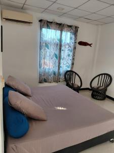 a large bed in a room with two chairs at Lovely beach hotel in Negombo