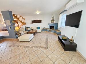 un soggiorno con divano e camino di Captain's Loft Villa a Marathokampos