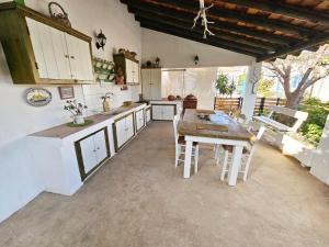 una cucina con mobili bianchi e un tavolo di legno di Captain's Loft Villa a Marathokampos