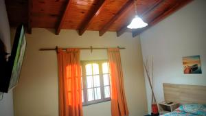 a bedroom with an orange curtain and a window at Buon Riposo in Córdoba