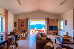 a living room with a view of the ocean at The Captain's View in Aegina