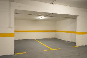 an empty parking garage with a yellow and white wall at The Watermill Lodge in Kolašin