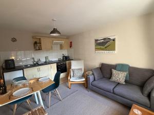 a living room with a couch and a table at 2 Nookdales Cottages in Ingleton