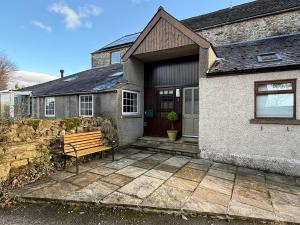 a house with a bench in front of it at 2 Nookdales Cottages in Ingleton