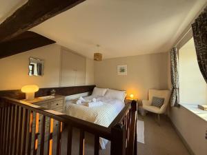 a bedroom with a bed and a chair on a balcony at 2 Nookdales Cottages in Ingleton