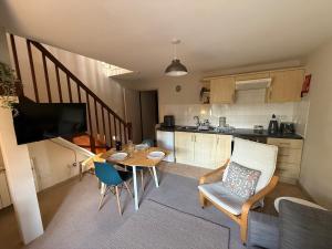a living room with a table and a kitchen at 2 Nookdales Cottages in Ingleton +22 photos