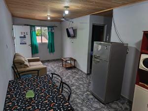 a living room with a table and a refrigerator at jazmin apart iguazu in Puerto Iguazú