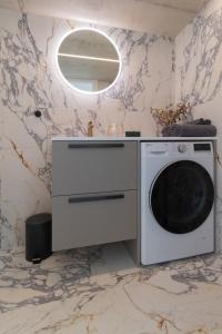 a washer and dryer in a room with a marble wall at Giruliai loft in Klaipėda +5 photos